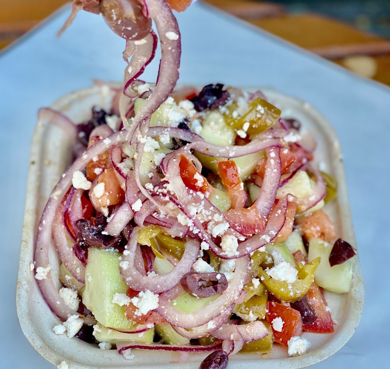 A fresh salad with feta, olives, and red onion